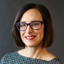 Head shot of Denise DeVries with a black and white blouse.