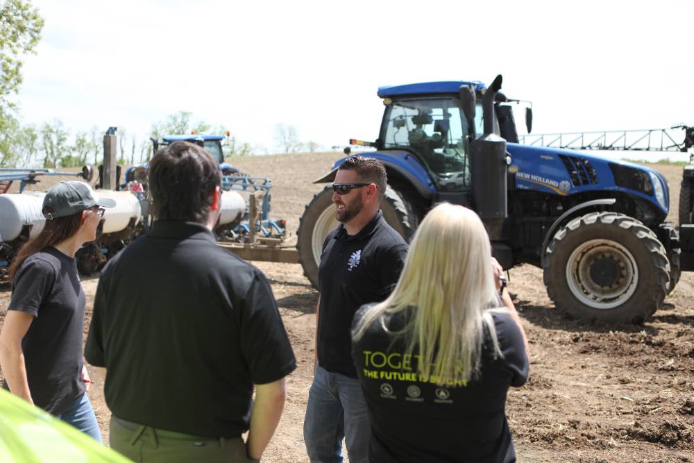 Point of view: As students are standing in a field looking at their instructor, they are all standing in front of a tractor
