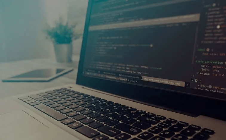 Laptop with dark screen and white code